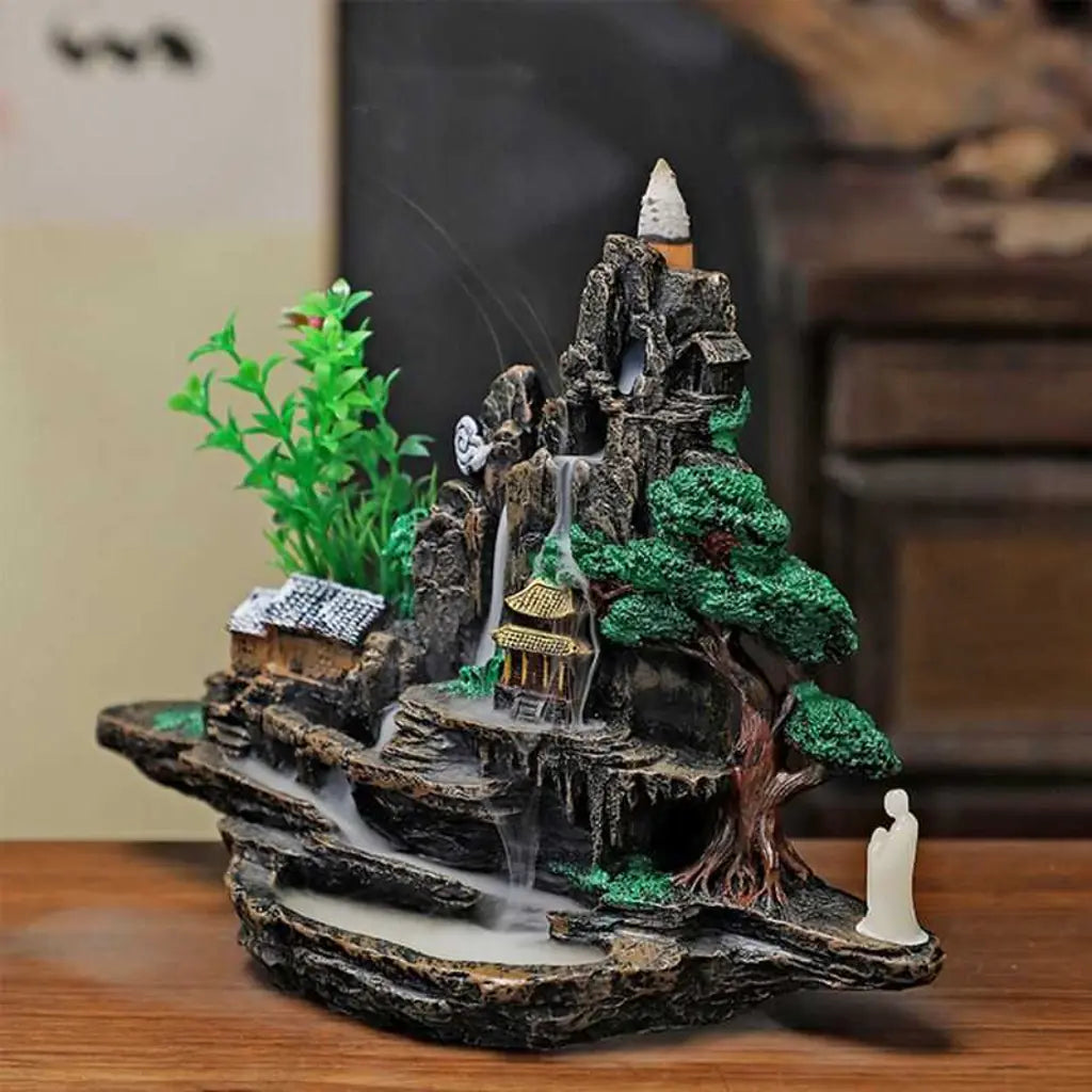 Cascada de humo encendida con cono en la cima — porta incienso con montaña, árbol de la vida, templo y figura de meditación, decoración zen para el hogar
