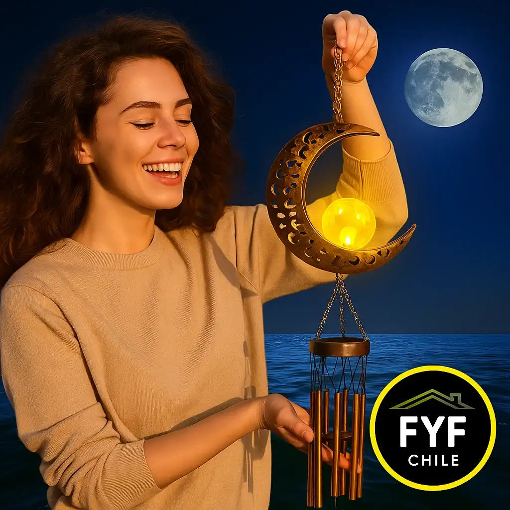 Mujer joven sonriente sosteniendo un colgante solar de luna con campanas doradas, disfrutando de un momento de relajación al atardecer en su hogar.