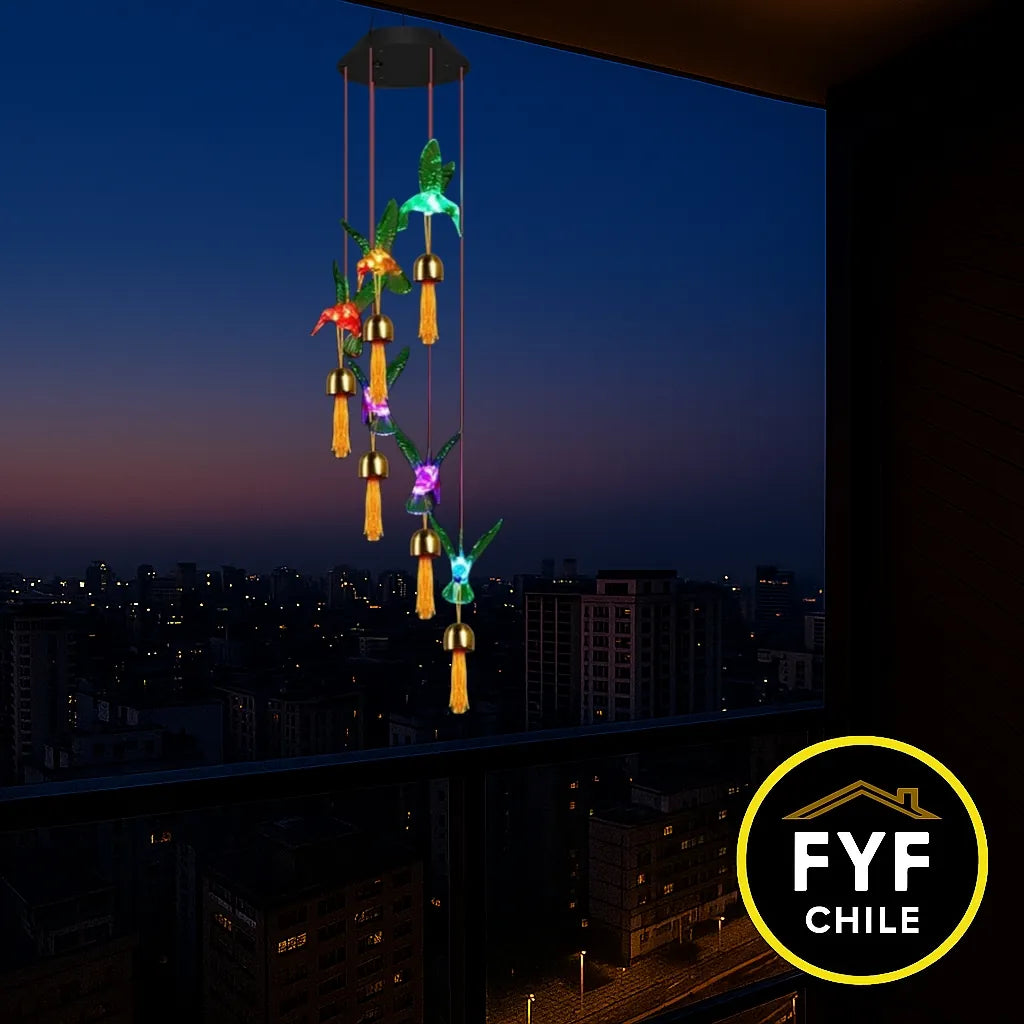 Colgante solar de colibrí iluminado colgando en balcón de edificio al atardecer