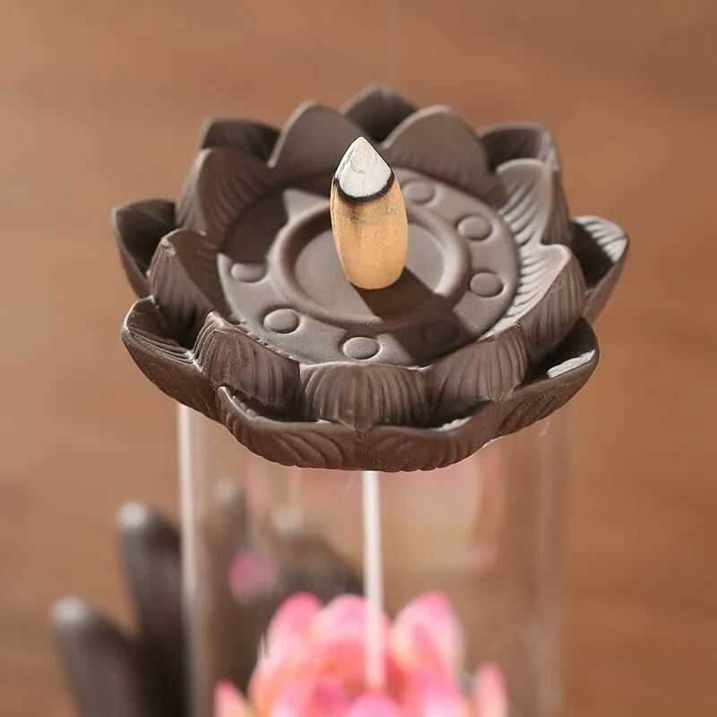Quemador de incienso mano y flor de loto en flujo inverso