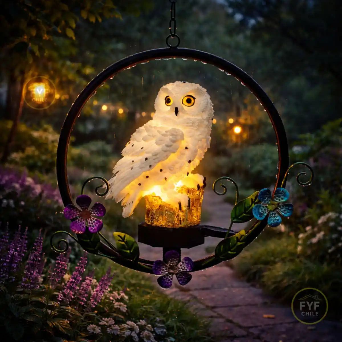 Colgante solar de búho LED encendido en jardín nocturno bajo la lluvia con flores decorativas