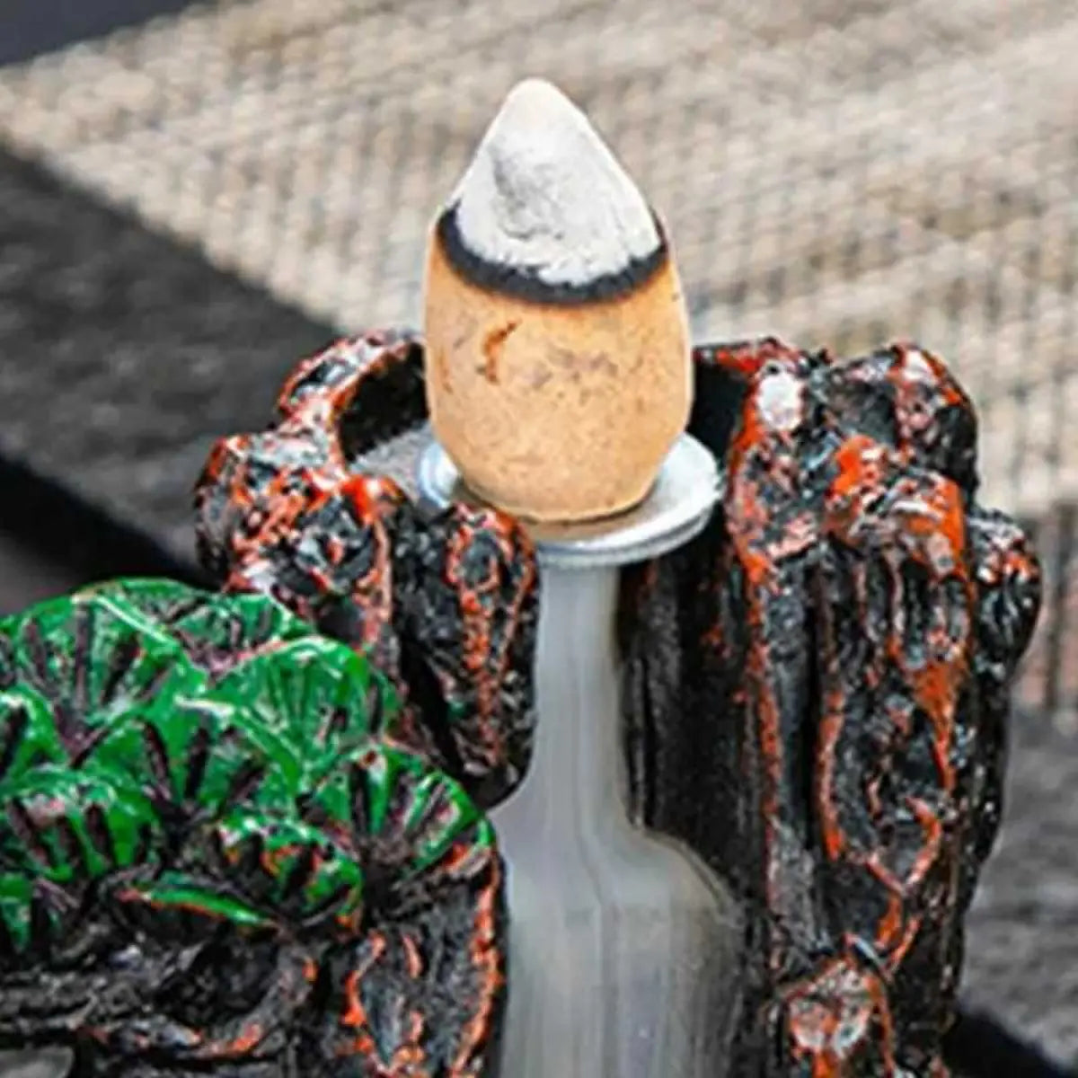 Detalle de cono de incienso para cascada de humo encendido sobre quemador zen, mostrando el efecto de humo descendente.