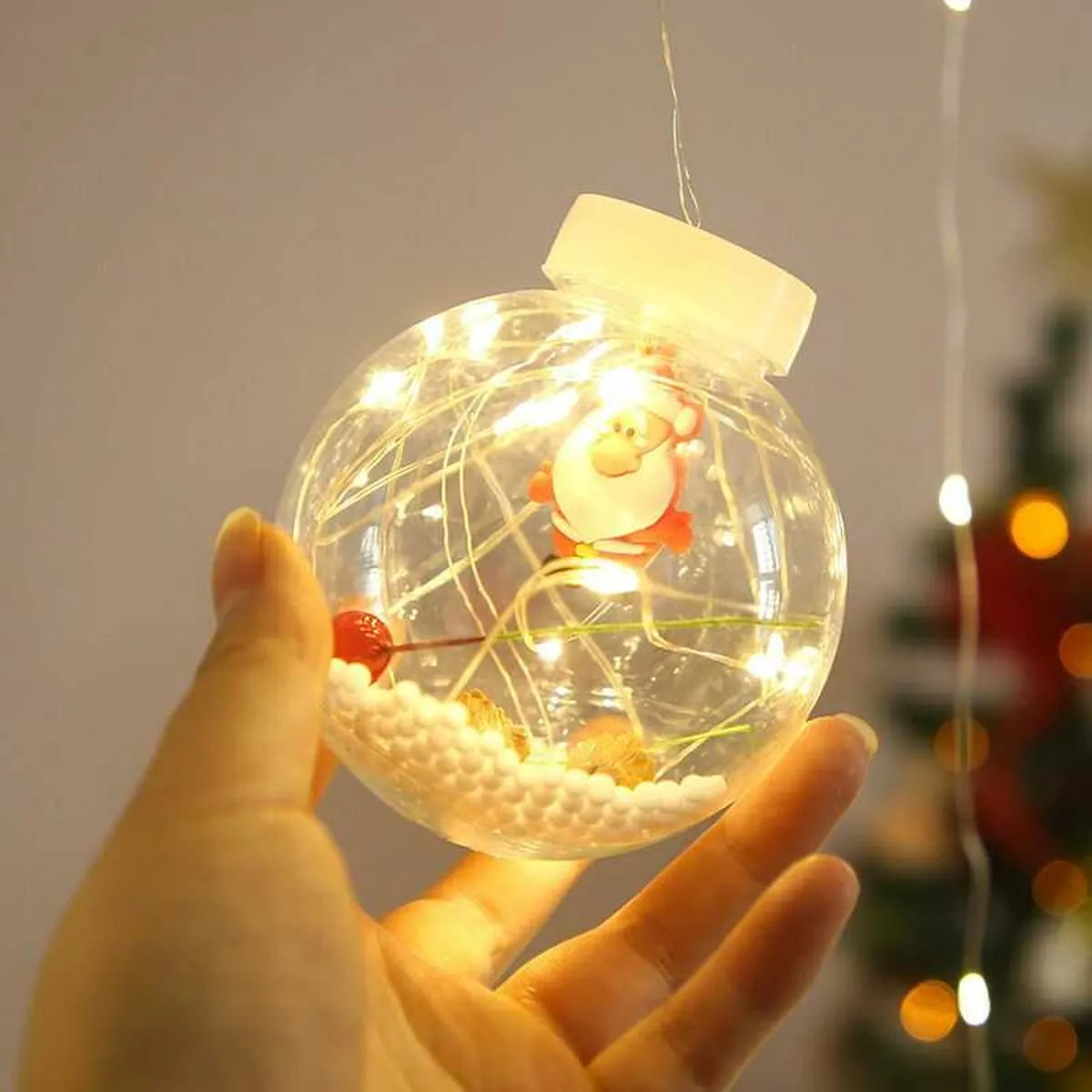 Esfera navideña solar LED de luz cálida sostenida en la mano con iluminación decorativa