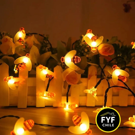 Guirnalda solar de abejitas LED encendidas en jardín de noche